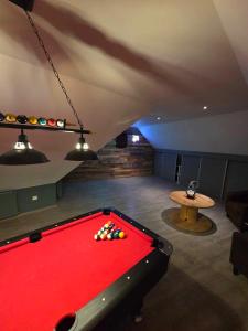 a room with a pool table in a basement at villa de luxe avec piscine et jacuzzi xxl in Dourlers