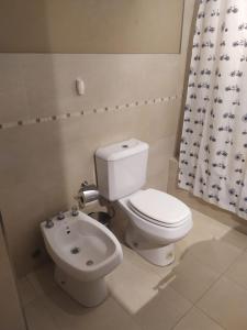 a bathroom with a white toilet and a sink at NORDELTA BAHIA GRANDE Monoambiente con cochera in Benavídez