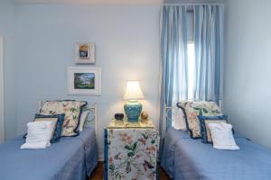 a bedroom with two beds and a table with a lamp at Cupola House in Edisto Island