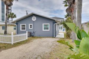 une maison bleue avec une clôture blanche dans l'établissement Cozy Ormond Beach Bungalow Steps to the Sand, à Ormond Beach