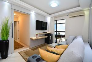 Una sala de estar con un sofá y un televisor. en Aconchego em Itapema a 30 metros do Mar - ITA002, en Itapema