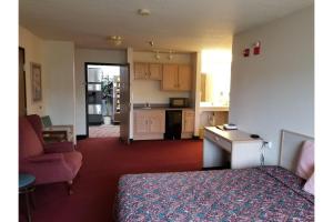a hotel room with a bed and a kitchen at Bilmar Inn & Suites by Hotel O Hwy 77 in Dell Rapids