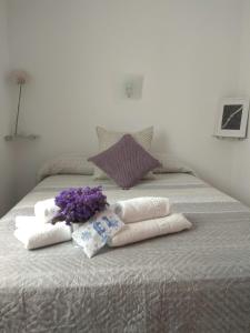 Una cama con toallas y flores púrpuras. en Delfin Playa, en Puerto Naos