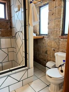 ein Badezimmer mit Toilette und Dusche in der Unterkunft El Encino in Tepoztlán