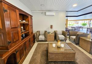 een woonkamer met een bank, stoelen en een tafel bij Ilha Flat 4-106 in Ilhabela