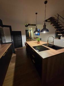 a kitchen with a sink and a counter top at villa de luxe avec piscine et jacuzzi xxl in Dourlers