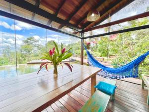a dining room with a wooden table and hammocks at Casa Rosa - Paraíso na Natureza piscina natural, Wi-Fi - 25 minutos do centro in Brasília