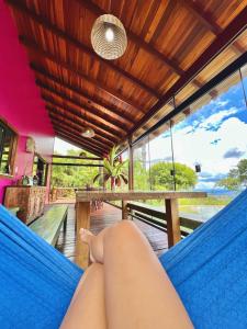 ブラジリアにあるCasa Rosa - Terra Dourada, Paraíso na Natureza, piscina natural, Wi-Fiのハンモックに横たわり海を眺めている人