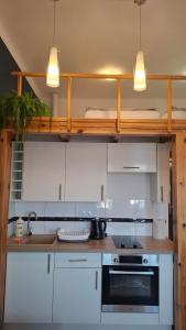 a kitchen with white cabinets and a stove top oven at Serce Przemyśla Classic in Przemyśl +46 photos