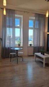 a room with a table and two chairs and windows at Serce Przemyśla Classic in Przemyśl