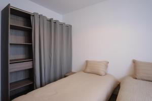 a bedroom with two beds and a curtain at Villa neuve 2025 - Calme & Confort, 8 pers, JURA 