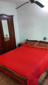 a bedroom with a red bed with a ceiling fan at Sil-Cris-Mar in Carhué