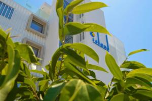 a building with a sign in front of a tree at Island Boutique Hotel in Larnaca