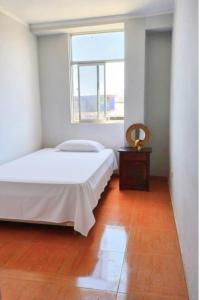 une chambre blanche avec un lit et une fenêtre dans l'établissement Modern and cozy apartment, à Jaén