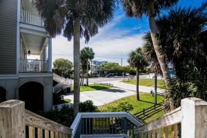 uma casa com um portão de madeira e palmeiras em Rich Tymes em Edisto Island
