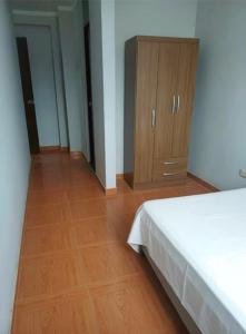 une chambre avec un lit et une armoire en bois dans l'établissement Modern and cozy apartment, à Jaén