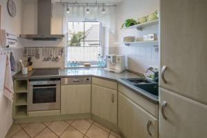 a small kitchen with a sink and a stove at Ferienhaus Wiek in Wiek auf Rügen 