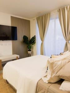 a bedroom with a white bed and a window at Aparta Suite en Santamarina - Escápate al Caribe in Santa Marta