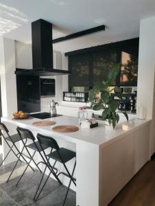 une cuisine avec un grand îlot blanc avec des chaises dans l'établissement Black Box village with garden, à Seferihisar