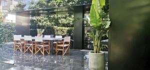 une salle à manger avec une table, des chaises et une plante dans l'établissement Black Box village with garden, à Seferihisar