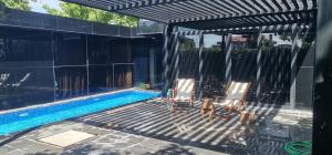 two chairs sitting next to a swimming pool at Black Box village with garden in Seferihisar