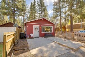 einen roten Schuppen mit weißer Tür und einem Zaun in der Unterkunft Big Bear Ski Hideaway! Cozy Cabin with Fenced Yard in Big Bear City Airport