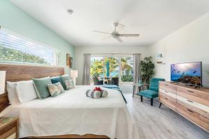 a bedroom with a large bed and a ceiling fan at The Tropical Breeze Cottage in Sand Bluff