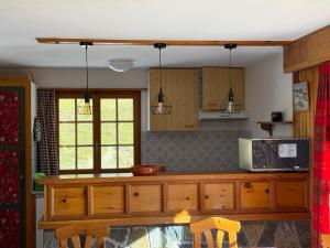 a kitchen with wooden cabinets and a counter top at Appartement Églantier in Evolène +11 photos