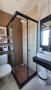 a bathroom with a shower and a toilet and a sink at Pousada Sol e Descanso by Easy Hotéis in Arraial do Cabo
