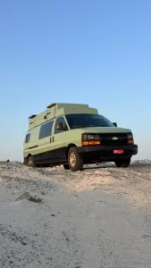 a camper van parked on the sand in the desert at Motorhome RV Oman in Muscat