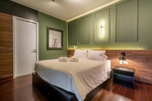 リマにあるSavini 2BR by Gekoの緑の壁のベッドルーム1室(大型ベッド1台付)