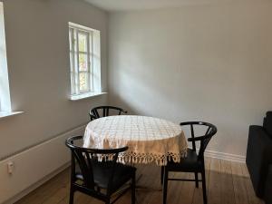 a dining room table with two chairs and a table with a tablecloth at Annexgården 9A in Tommerup