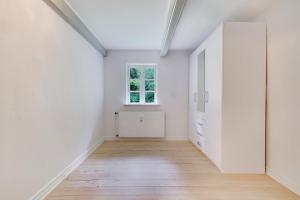 an empty room with white walls and a window at Annexgården 9A in Tommerup