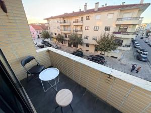 a balcony with two tables and chairs on a building at Spacieux appartement à 200 m de la plage in Ovar