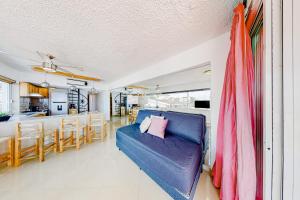 a living room with a blue couch and a kitchen at Torre Malibu, Loft # 805 in Puerto Vallarta