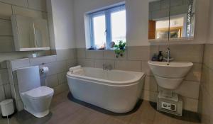 MartonにあるBright, Stylish 1 KS Bed Bungalow with Private Gardenの浴槽、洗面台、トイレを備えたバスルーム +21枚の写真