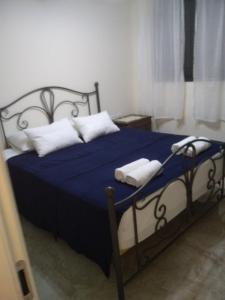 a bedroom with a blue bed with two towels on it at Ilana's Place in Qiryat H̱aroshet
