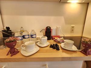 un comptoir avec des tasses, des soucoupes et des bouteilles d'eau dans l'établissement Relaxing Studio with a private terrace, à Luxembourg