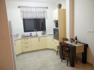 a small kitchen with a table and a sink at Ilana's Place in Qiryat H̱aroshet