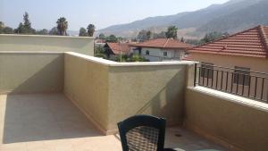 a balcony with a chair and a view of a mountain at Ilana's Place in Qiryat H̱aroshet