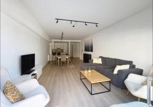 een woonkamer met een bank en een tafel bij Apartment Sunset Koksijde in Koksijde