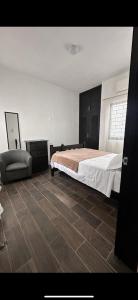 a bedroom with a bed and a chair at Departamento moderno con wifi y AC in Ciudad del Carmen
