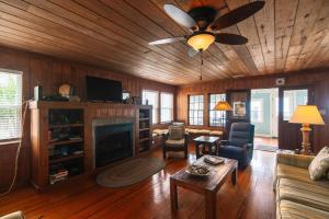 uma sala de estar com uma lareira e uma ventoinha de tecto em Commander em Edisto Island