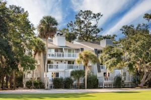 a large house with palm trees in front of it at Driftwood Villa 256 - Slo Drift in Edisto Island
