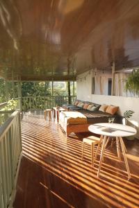 ein Wohnzimmer mit einem Sofa und einem Tisch auf einer Terrasse in der Unterkunft Casa Oh - Oceanview Guesthouse in Uvita