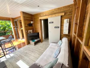 a living room with a couch and a television at BUNGA-LODGE (bungalow 4* avec piscine privée) in Douville +40 photos