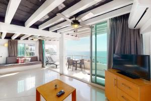 een woonkamer met een televisie en uitzicht op de oceaan bij Torre Malibu, PH # 901 in Puerto Vallarta