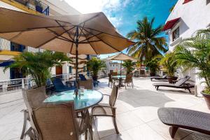een patio met een tafel, stoelen en parasols bij Torre Malibu, PH # 901 in Puerto Vallarta