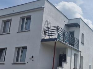 a white building with a balcony on the side of it at Hostel Berberysowa in Wrocław
