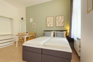 a large bed in a room with a table at LUMA Apartments in Dresden